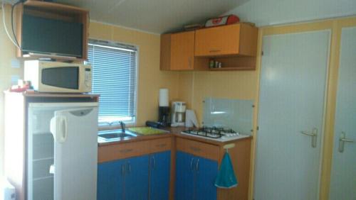CerclesETANG PRE DE LA FONT的厨房配有蓝色橱柜和白色冰箱
