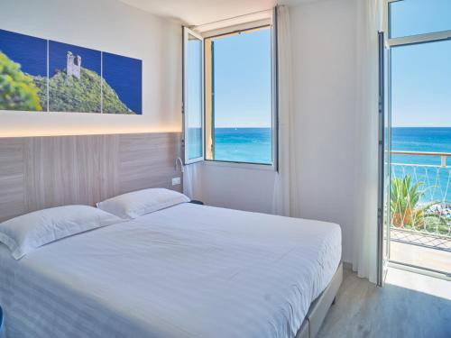 菲纳莱利古雷美杜莎酒店的一间卧室设有一张床,享有海景