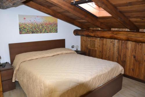 皮耶特拉佩尔托萨B&B La Casa Sulla Roccia的一间带一张床的卧室,位于带木制天花板的房间内