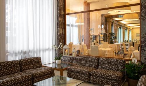 利多迪耶索罗奥罗拉酒店的一间设有两把椅子和一张桌子的等候室