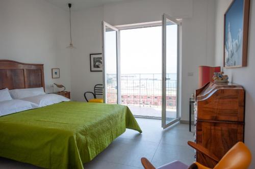 那不勒斯B&B ICHOME NAPOLI - Maison d'Artiste的一间卧室设有一张绿色的床和滑动玻璃门