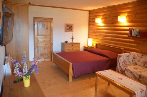 丰罗穆索尔比耶红木屋公寓的一间卧室设有一张床和木墙