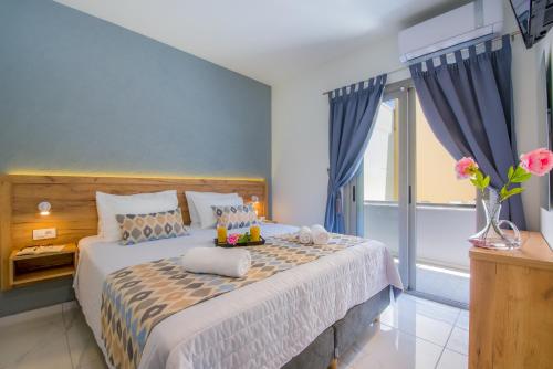 普拉塔尼亚斯Linda Apartments Platanias的一间卧室配有一张带蓝色墙壁的大床