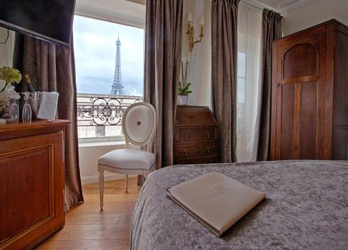 巴黎埃菲尔托卡德奥酒店的一间卧室配有一张床,享有艾菲尔铁塔的景色