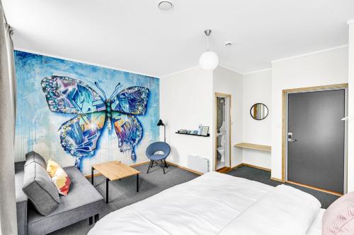 阿伦达尔Lille Hotell的一间卧室配有一张床和蝴蝶画