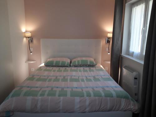 瑞姆巴赫普莱斯格布维尔Un Air D'alsace的一间卧室配有带两个枕头的床和窗户