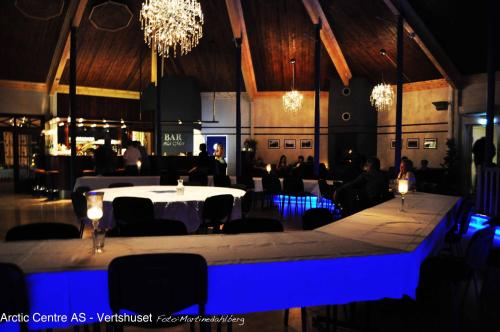 GratangenArctic Inn的一间设有白色桌子和蓝色灯光的用餐室