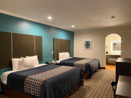 休斯顿Regency Inn & Suites- NW Houston的酒店客房设有两张床和蓝色的墙壁。