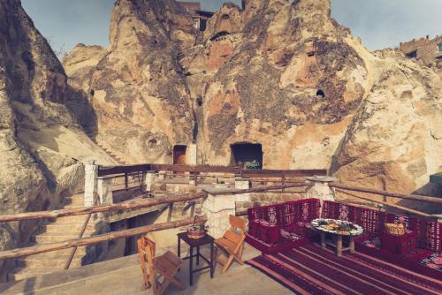 内夫谢希尔Cappadocia Ennar Cave Swimming Pool Hot & SPA的山前带桌椅的房间