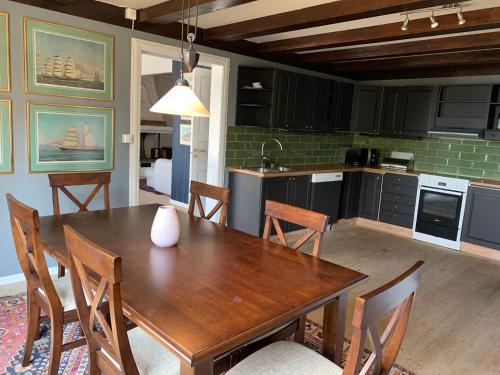 MoldegardMoldegaard Farmhouse - Apartment A的厨房以及带木桌和椅子的用餐室。