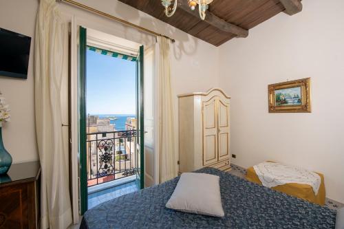 阿马尔菲Residenza Del Duca Rooms & Apartments的一间卧室设有一张床和一个大窗户