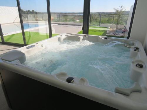 阿尔沃尔Villa Ria Alvor- Swimming pool & Jacuzzi的窗户客房内的大浴缸