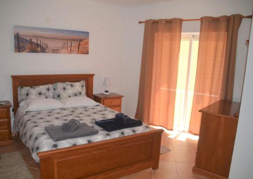 维拉多比斯坡Casa Flora T1 - Vila do Bispo的一间卧室配有一张床,上面有两条毛巾