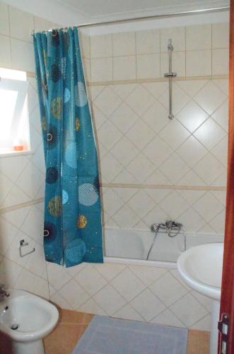 维拉多比斯坡Casa Flora T1 - Vila do Bispo的浴室设有蓝色的浴帘和水槽