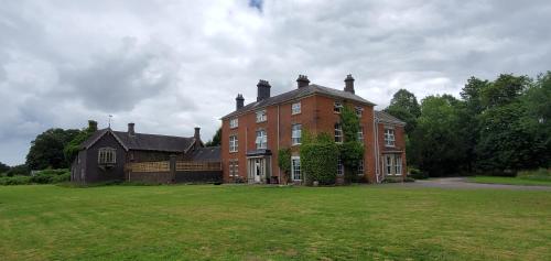 考文垂Coundon Lodge Coventry的一座大型红砖房子,有大草地庭院