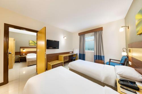 沙迦沙迦城市麦克斯酒店的酒店客房,设有两张床和镜子
