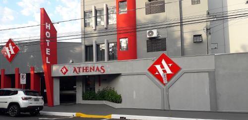 阿拉萨图巴Hotel Athenas e Convenções的停在大楼前的白色汽车