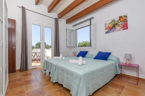 比尼贝卡Villa Astur的一间卧室配有一张带蓝色枕头的大床