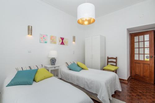 西尔韦斯Casa Jacarandá的白色墙壁客房的两张床