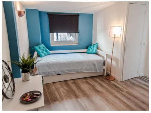 阿维尼翁Aventure Avignonnaise - ROOFTOP TERRASSE - INTRAMUROS - CITY CENTER的一间卧室拥有蓝色的墙壁,配有一张带蓝色枕头的床。