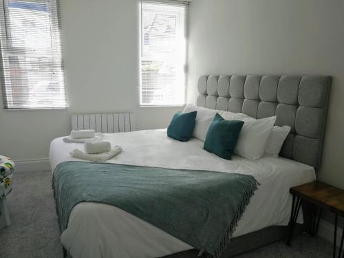 布里斯托Derby Den by Cliftonvalley Apartments的卧室配有带蓝色枕头的大型白色床