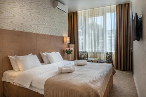 敖德萨伯恩公寓的一间酒店客房,设有一张大床和一个大窗户