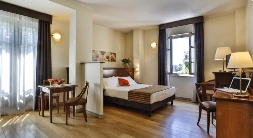 都灵Hotel & Residence Torino Centro - Stazione Porta Susa的酒店客房配有一张床铺、一张桌子和一张书桌。