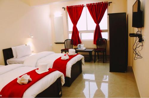 甘托克Bankhim Residency (Parking available)的酒店客房,配有两张带红白毯子的床