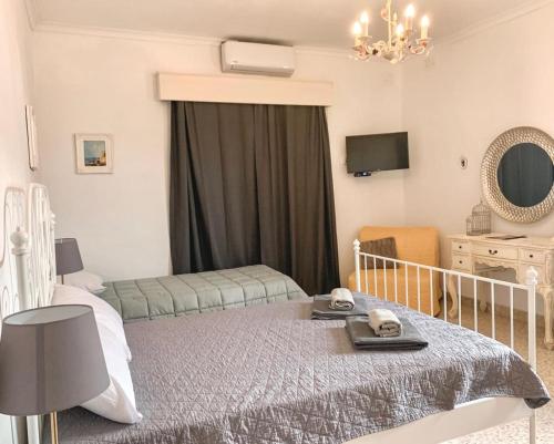 圣保罗湾城Villa Zammitella的一间卧室配有一张床、一把椅子和镜子