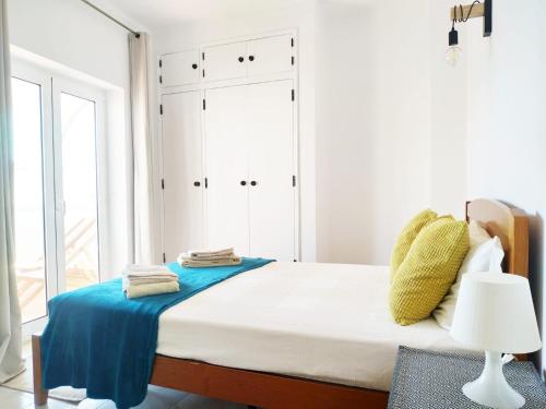 塔维拉Tavira Lovers - City Centre Apartments的白色卧室配有一张带蓝色床单的大床