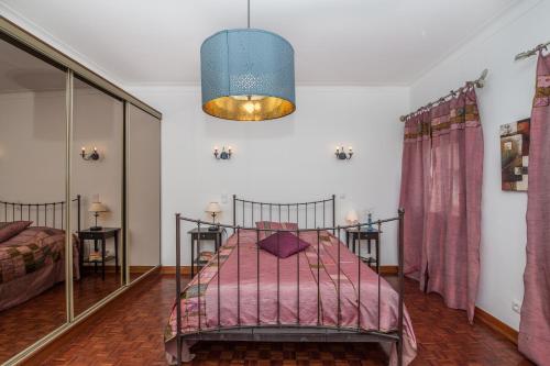 西尔韦斯Casa dos Pais的一间卧室配有一张带粉色毯子的床