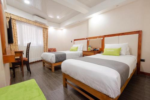 利马Ayenda La Luna Inn的酒店客房 - 带两张床、一张桌子和一把椅子