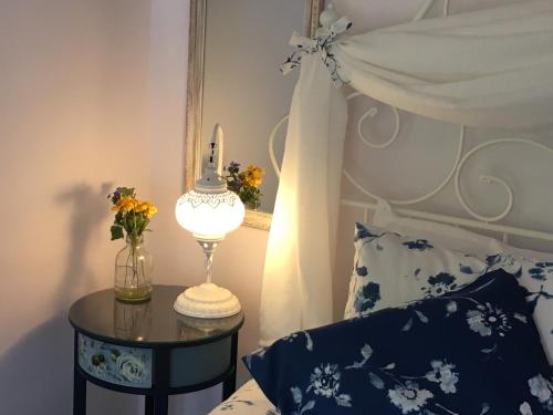 Stefan StambolovoSunflower Guest House Bulgaria的一间卧室配有一张床和一张带台灯的桌子