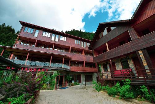 乌宗Aygün Suites Hotel&Bungalow UZUNGÖL的一座大型木制建筑,前面设有阳台