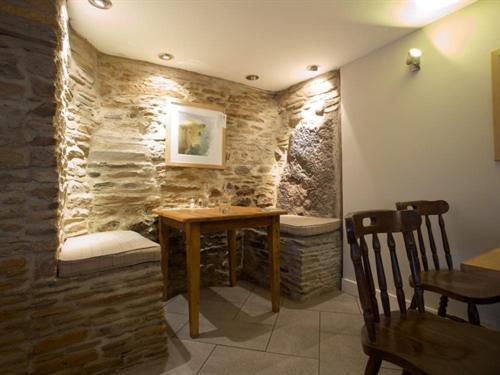 艾维布里奇船锚酒店的一间设有桌子和石墙的用餐室