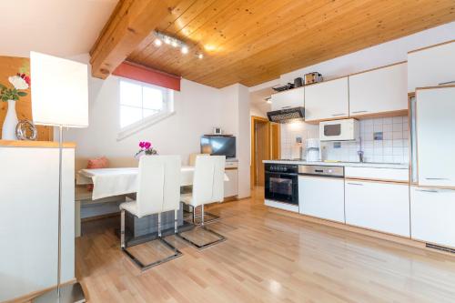 弗拉绍安纳斯公寓的厨房配有白色橱柜和桌椅