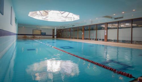 卡洛卡罗泰尔伯特酒店的大楼内一个蓝色的大型游泳池