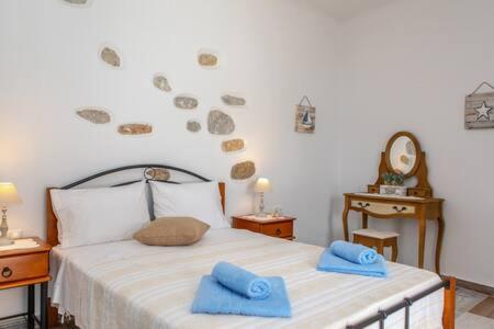 Glinado NaxosVintage House Naxos的一间卧室配有一张带蓝色毛巾的床