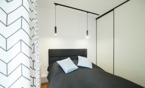 波兹南Villa Wenecja Apartament ALBERO的一间卧室配有一张带黑色床头板的床