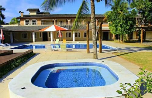 卡拉瓜塔图巴Pousada Porto do Rio的房屋前的大型游泳池