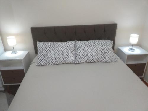 里约热内卢Mega Apartamento的一间卧室,配有带2个床头柜的床