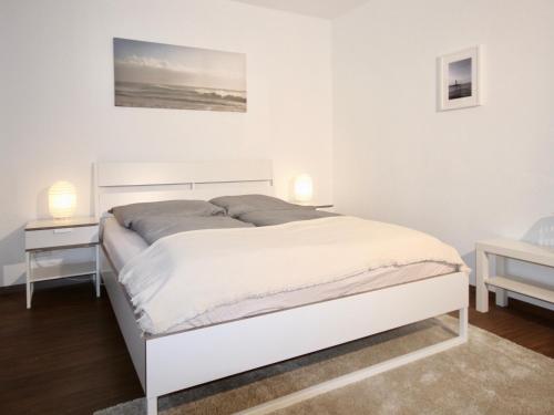 波鸿Apartmenthaus in der Arnoldstraße的白色卧室内的一张白色床,配有两盏灯