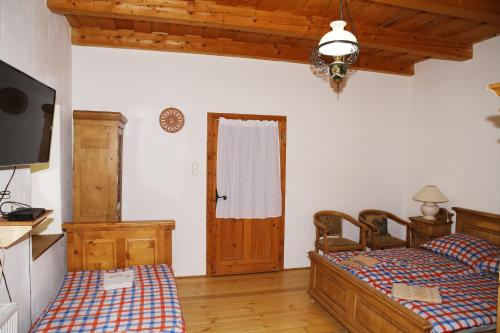 GarábTanya Üdülőház的一间卧室配有两张单人床和一台电视机