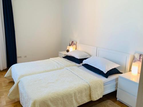 唐吉莫利尼Lavender Bay Apartment B13的一间卧室配有两张带白色床单和枕头的床。