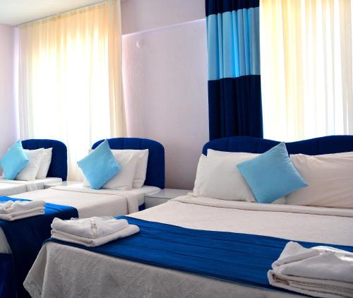 古穆杜尔古穆尔杜尔马伟德尼兹酒店的客房配有两张带蓝白色枕头的床。