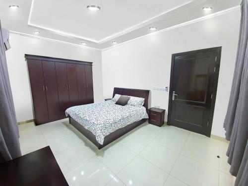阿哈达Al Estraha Al Raqia Vila的一间卧室配有一张床和一个黑色橱柜