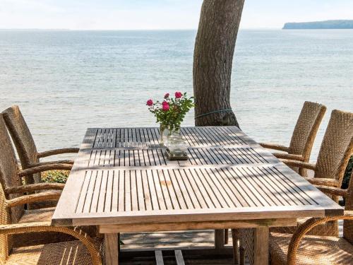 桑德比耶特6 person holiday home in Bjert的海滩上带花瓶的木桌