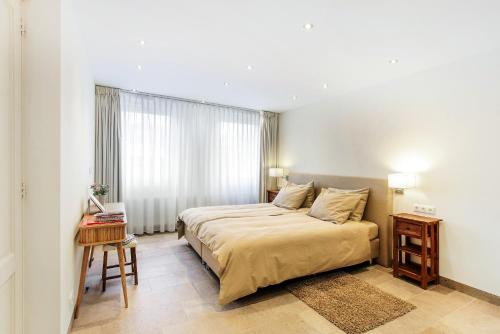 阿姆斯特丹Artis Plantage Apartment的一间卧室配有一张床、一张桌子和一个窗户。