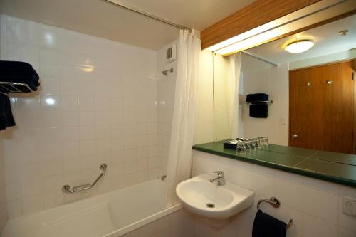 皇后镇瑞士贝尔皇冠峰度假酒店的带浴缸、水槽和镜子的浴室
