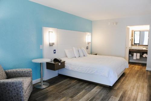 圣奥古斯丁海滩圣奥古斯丁丽晶酒店的配有一张床和一把椅子的酒店客房